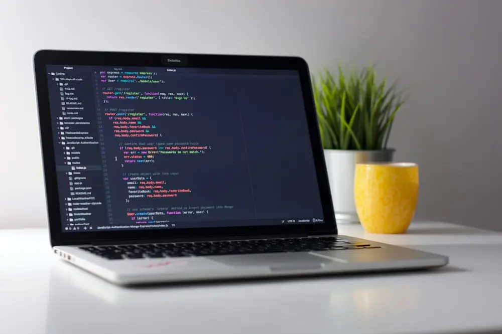 Portátil con el diseño de una página web en pantalla sobre una mesa de trabajo