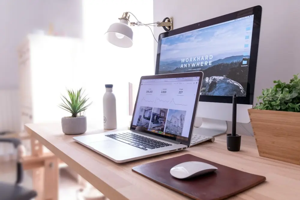 Escritorio con portátil y ordenador que muestran las soluciones digitales del catálogo del Kit Digital