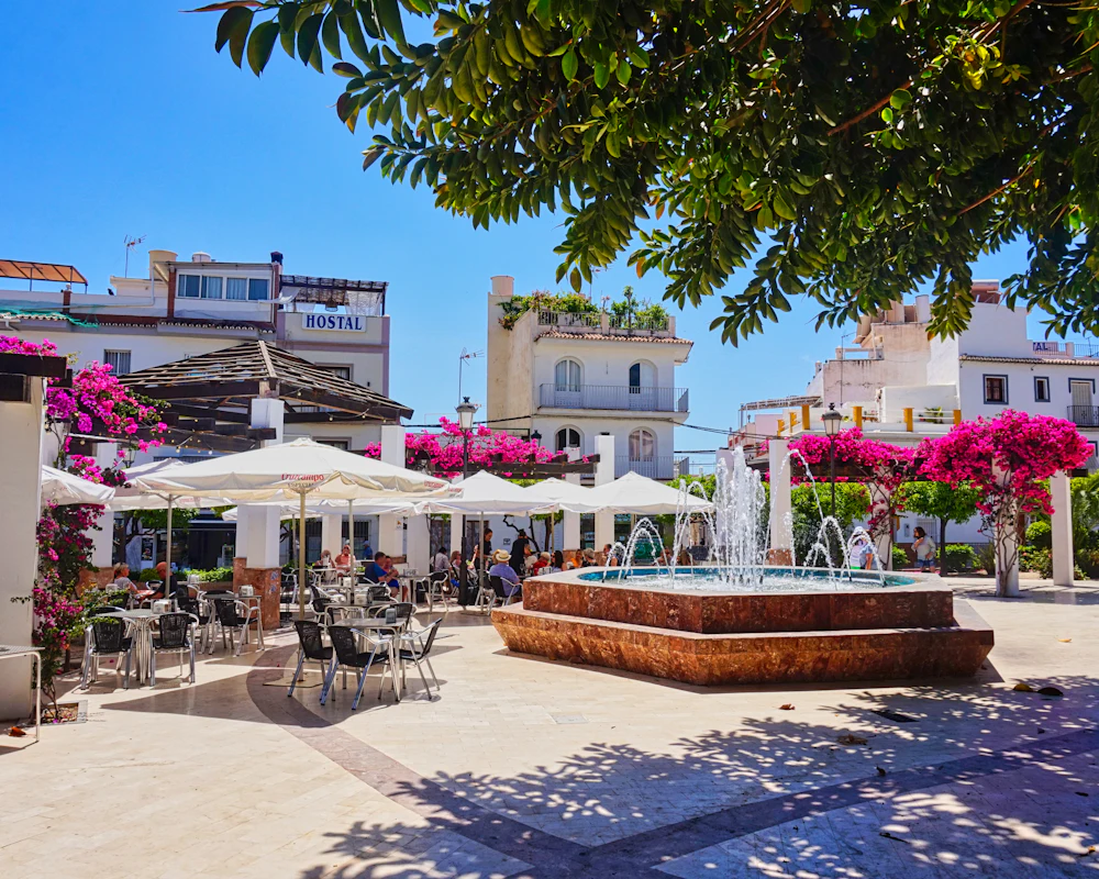 Plaza con terrazas y flores en la Costa del Sol